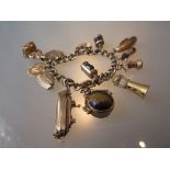 9ct Gold curb link charm bracelet attached with multiple charms and a seal