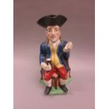 19th Century Staffordshire snuff taker Toby jug of a seated figure wearing a tricorn hat holding a