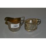 Small silver cream jug and an oval silver mustard with blue glass liner