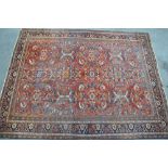 Large Hamadan carpet with an all-over stylised floral design on a brick red field with wide