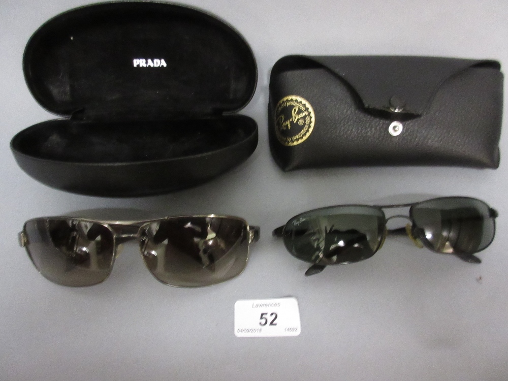 Two pairs of sunglasses by Ray-Ban and Prada