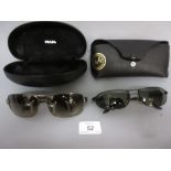 Two pairs of sunglasses by Ray-Ban and Prada