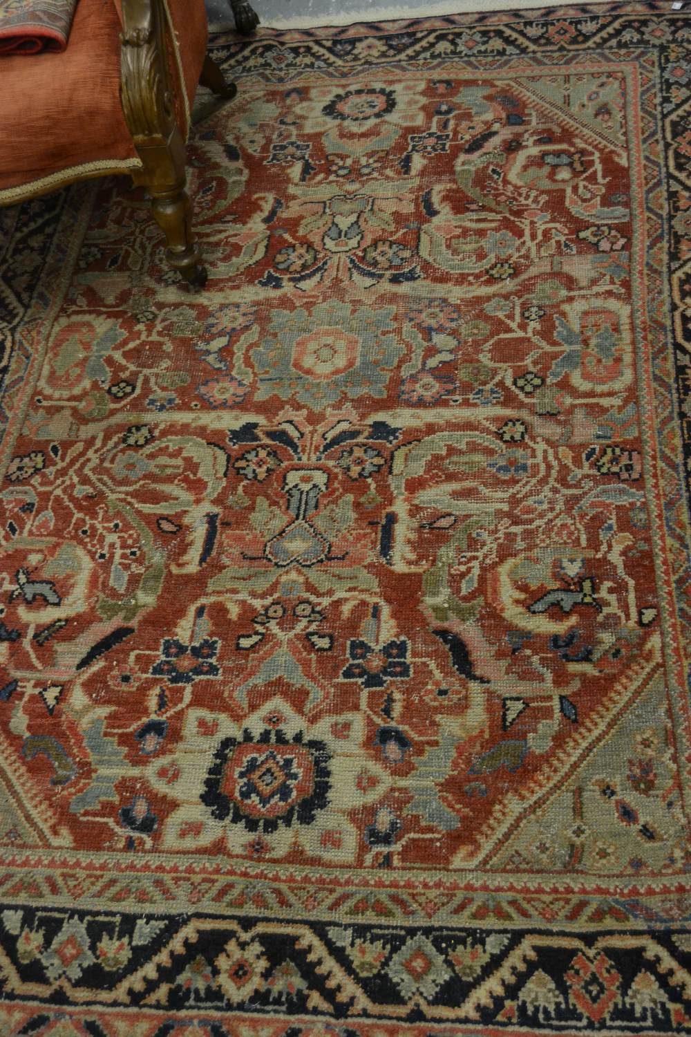 Kurdish rug with an all-over stylised medallion and floral design on a red ground with borders