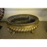 Regency brass jardiniere of low oval form with embossed decoration,