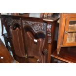 Edwardian carved mahogany display cabinet with two shaped bevelled glass inset doors enclosing