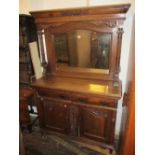 Small late Victorian carved oak sideboard with a mirrored canopy back above two drawers and two