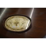 Oval two handled leather covered and silk needlework panelled tray decorated with bows and flowers