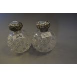 Pair of cut glass perfume bottles with silver embossed tops