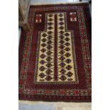 Belouch rug of geometric floral design with multiple borders on a wine ground