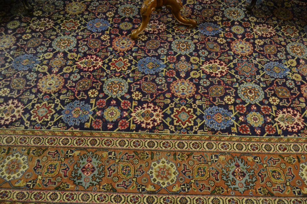 Tabriz carpet with an all-over stylised flower head design on a midnight blue ground with borders,