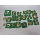 Collection of twenty various military badges mounted on green felt cards