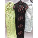 Two full length Chinese dresses, size 38, one in black decorated with silver thread and red sequins,