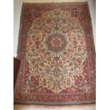 Small Kashan rug with a medallion and all-over floral design on an ivory ground with borders,