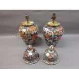 Pair of 19th Century Imari ovoid jars with covers decorated in conventional iron red and blue (the