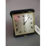 Blue leather cased travelling alarm clock, the silvered dial with Roman numerals,