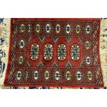 Three small Pakistan rugs of Turkoman design together with a small flat weave rug