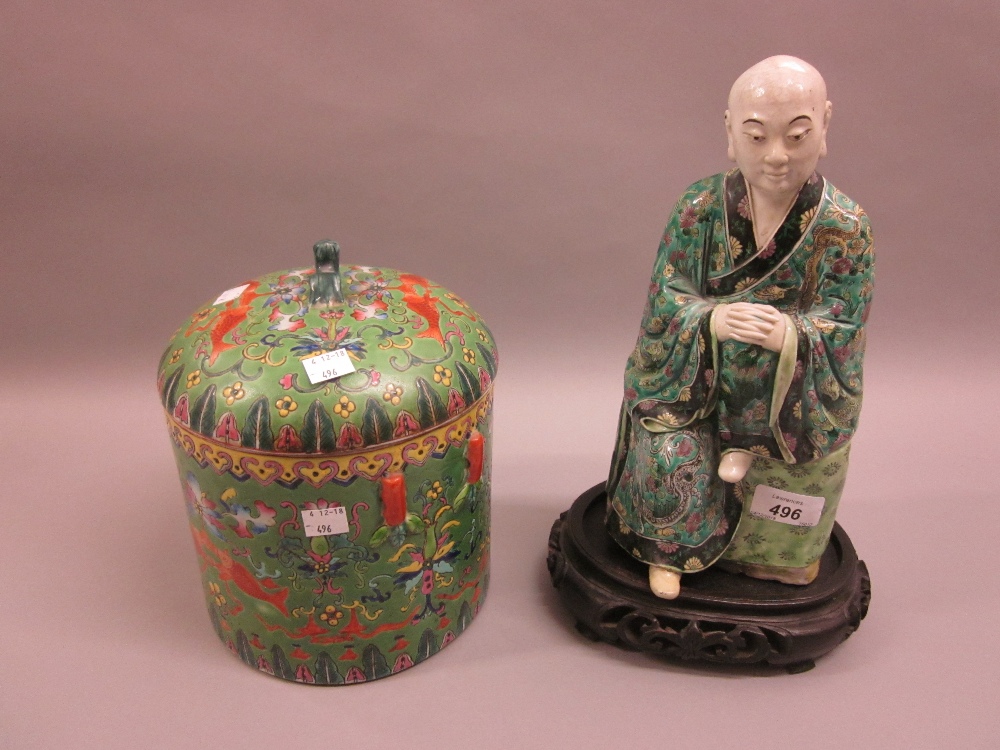 Oriental hard paste porcelain figure of a seated Buddha having floral enamel decoration on a wooden
