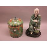 Oriental hard paste porcelain figure of a seated Buddha having floral enamel decoration on a wooden