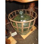 Large glass carboy housed in a metal basket