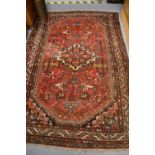 Hamadan rug with a medallion and all-over stylised floral design on red ground with borders