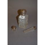 Silver top cut glass perfume bottle with floral embossed cover,