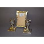 Pair of Sheffield silver low candlesticks on square bases and a rectangular silver photograph frame
