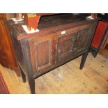 Antique oak aumbry with a single panelled door raised on square tapered supports (17th Century and