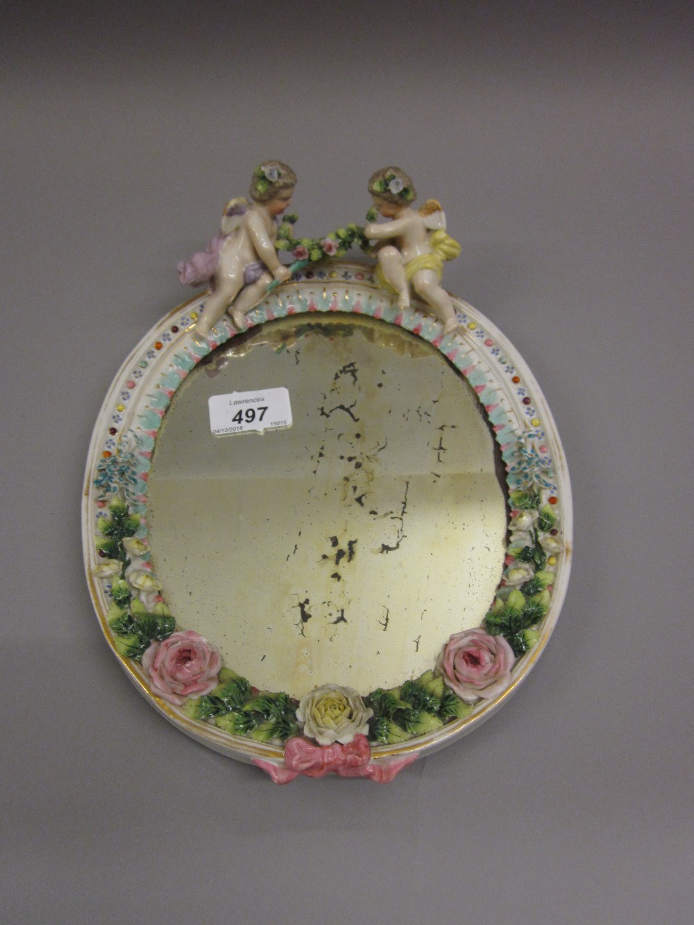 Continental porcelain oval dressing table mirror having all-over floral decoration and mounted with