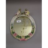 Continental porcelain oval dressing table mirror having all-over floral decoration and mounted with