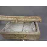Wicker hamper containing a collection of various vintage Christening gowns