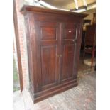 Antique oak two door wardrobe, the moulded top above double fielded panel doors,