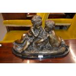 Brown patinated bronze group of two cherubs mounted on an oval marble base