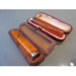 Two gold mounted amber coloured cigarette holders
