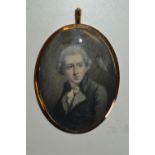 Oval gold plated framed portrait miniature of a bewigged gentleman