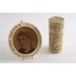 A 19TH CENTURY CHINESE CYLINDRICAL IVORY BOX with carved & pierced decoration & a screw cover, and a