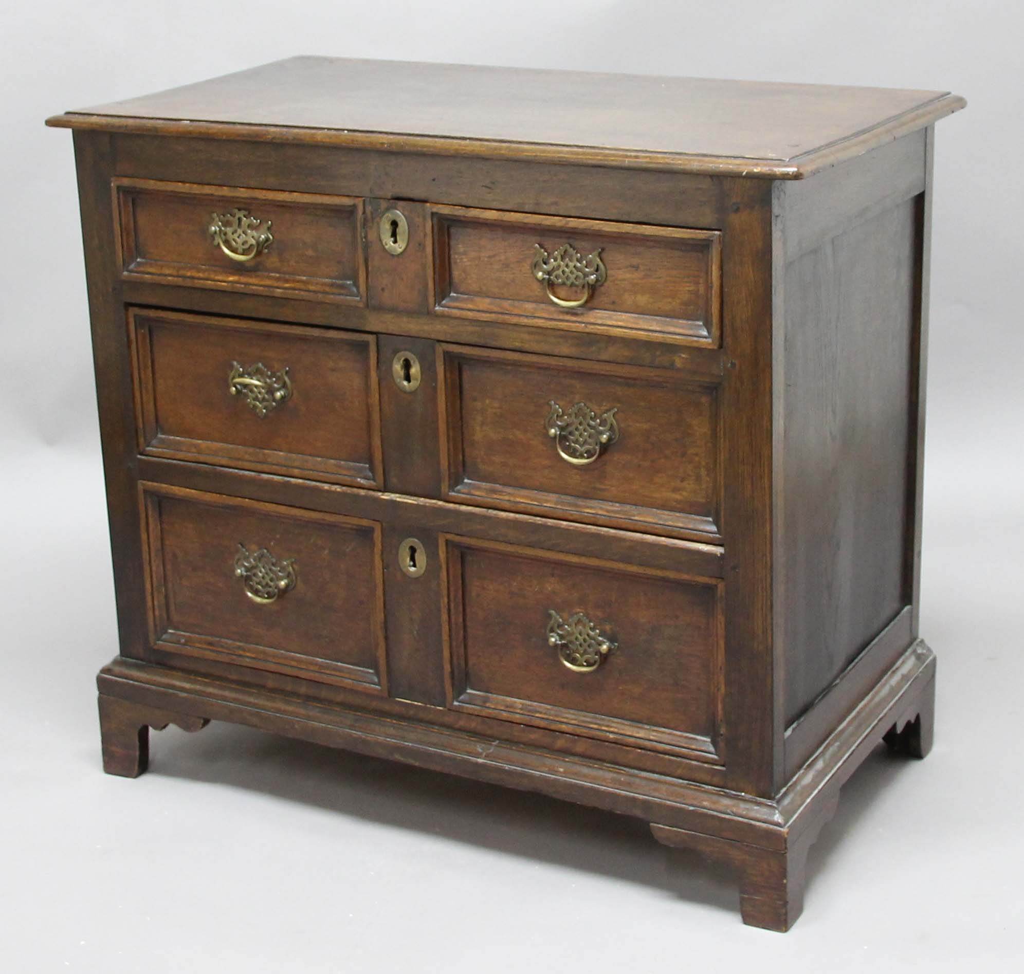 OAK CHEST OF DRAWERS, 18th century, with three graduated drawers and bracket feet, height 86cm,