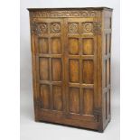 OAK WARDROBE, 18th century and later, the pair of panelled doors with two profile busts beneath an