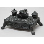 ANGLO-INDIAN EBONY STANDISH, early/mid 19th century, the shaped rectangular stand deeply carved with