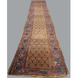 NORTH WEST PERSIAN RUNNER the chocolate field of stylised plants enclosed by indigo borders, 230cm x