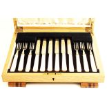 AN ART DECO CASED SET OF SIX PAIRS OF FRUIT/DESSERT KNIVES & FORKS with simulated ivory handles,