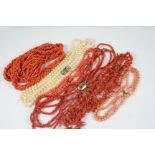 A FOUR ROW CORAL BEAD NECKLACE set to a gold clasp, with centre section containing hair, 41cm. long,