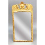 GEORGE I GILT PIER MIRROR, the shaped rectangular bevelled plate beneath a crest flanked by a pair