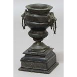 BLACK MARBLE AND BRONZE MOUNTED URN, with a pair of lion mask swing handles and stepped base, the