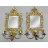 PAIR OF GILT METAL MIRRORED WALL LIGHTS, the bevelled square plate inside a frame with a mask,