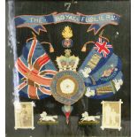 THE ROYAL FUSILIERS, a woolwork embroidery of their crest and flags above two photographs, 50cm x