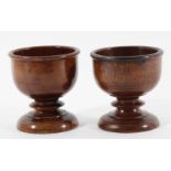 PAIR OF MAHOGANY GOBLETS the circular bowls with incised banding on knopped stems and turned,