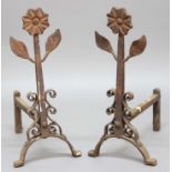 PAIR OF ARTS AND CRAFTS STYLE WROUGHT IRON FIRE DOGS, with flower head terminals, height 63cm (2)