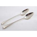 A PAIR OF GEORGE III OLD ENGLISH PATTERN BASTING SPOONS with bright-cut borders, one crested, one