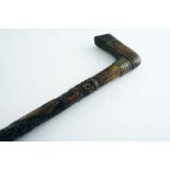 A 20TH CENTURY CARVED WOODEN FOLK-ART WALKING STICK with a fish, a lizard & initials encircling