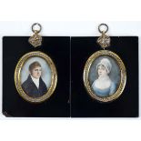 A PAIR OF REGENCY MINIATURE PORTRAITS of a gentleman and his wife, he wearing black jacket, she with